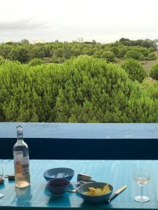 een tafel met kommen eten en een fles wijn bij Appartement classé, vue mer, clim, wifi, parking in La Grande-Motte