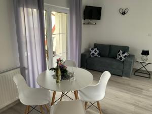 a living room with a table and chairs and a couch at Apartamenty Pod Cisem in Kudowa-Zdrój