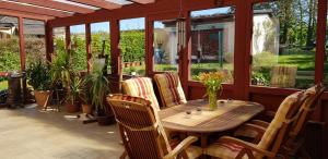 - une table et des chaises en bois sur une terrasse couverte avec moustiquaire dans l'établissement Ferienwohnungen Gronen, à Boppard