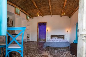 Un dormitorio con una cama y una silla azul. en צימר old school, en Ein Kinya