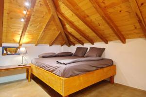 Bett in einem Zimmer mit Holzdecke in der Unterkunft Angel Sunset suite in Patitiri