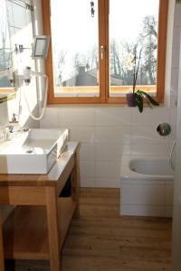 a bathroom with a sink and a tub and a window at Pension Christina in Unterach am Attersee