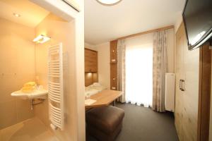 シュラートミンクにあるEdelweiss Apartmentsの洗面台とバスルームが備わるホテルルームです。