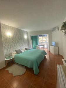Schlafzimmer mit einem großen grünen Bett in der Unterkunft Fun-sun in Fuengirola