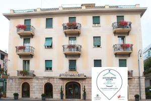 a building with balconies and a sign in front of it at Hotel Giulio Cesare in Rapallo