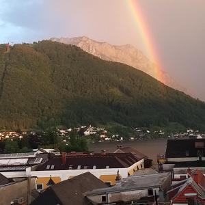 a rainbow over a city with a mountain at Marktplatz Traunsee LAKE View in Gmunden