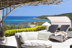 un patio con sofá y vistas al océano en Villa Iris - Ela Sardinia in Villa en San Teodoro