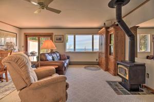 uma sala de estar com um fogão a lenha e um sofá em Lake Superior Beachfront Home - 15 Mi to Duluth! em Clifton