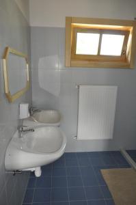 a bathroom with a sink and a mirror and a window at Bak Vendéglő faházak in Gyulakeszi