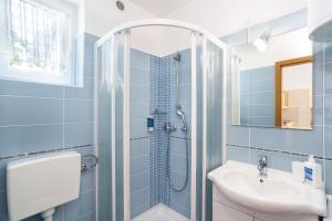 a blue bathroom with a shower and a sink at Apartments MEDVED in the historic center in Koper +39 photos