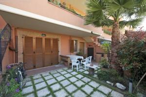 a patio with a table and chairs and a palm tree at B&B La Palma in Pescara