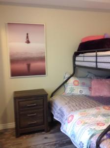 a bedroom with a bunk bed and a wooden nightstand at Sandy Cove Cottage in Crystal Beach
