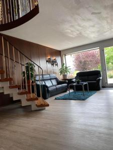 ein Wohnzimmer mit einem Sofa und einer Treppe in der Unterkunft Sonnenstrand Hotel in Butjadingen