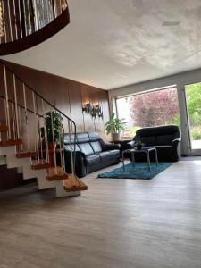 a living room with a couch and a staircase at Sonnenstrand Hotel in Butjadingen