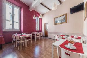 a restaurant with tables and chairs and red walls at Hotel Mimosa Pantheon in Rome