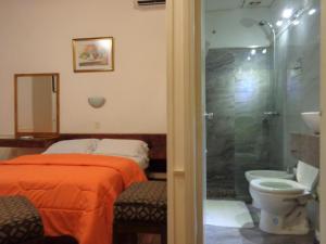 a bedroom with a bed and a shower and a toilet at Hotel Casablanca Montevideo in Montevideo