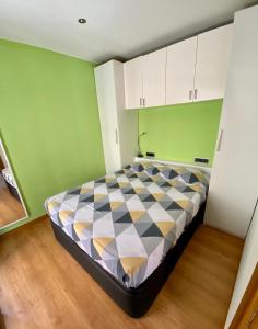 - une chambre avec un lit dans une pièce aux murs verts dans l'établissement Pequeño loft para dos, à Sant Feliu de Guíxols
