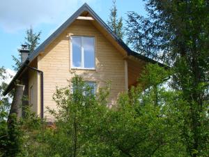 a house with a window on the side of it at Domek nad stawem in Łabowa