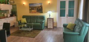 a living room with a green couch and a table at Apartment Thomas in Vipava