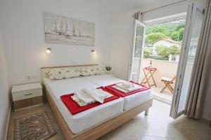 a bedroom with a bed with towels on it at Apartmani Srdoč in Baška