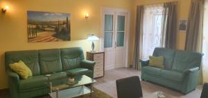 uma sala de estar com dois sofás verdes e uma mesa em Apartment Thomas em Vipava