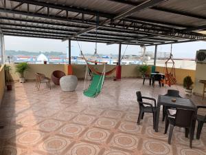 um quarto com uma rede de descanso, mesas e cadeiras em Residencial Turístico Rio Guayas em Guayaquil