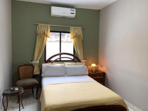a small bedroom with a bed and a window at Residencial Turístico Rio Guayas in Guayaquil