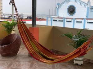 a hammock in a room with a view of a building at Residencial Turístico Rio Guayas in Guayaquil