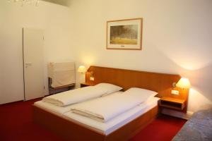 una camera da letto con un grande letto con lenzuola bianche di Alameda ad Amburgo