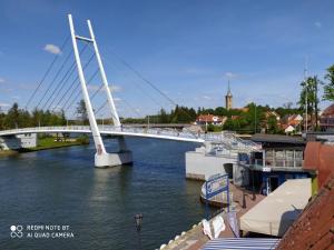 a white bridge over a river with boats in it at Apartamenty przy Promenadzie in Mikołajki