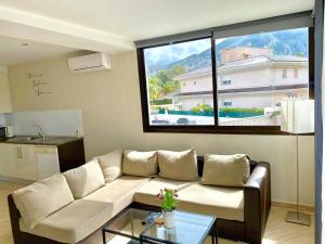 a living room with a couch and a large window at The Villa by Albir Proper Properties in Albir