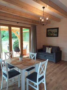 a dining room with a table and chairs and a couch at Domek pod Groniem in Mizerna
