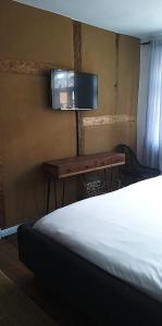 een slaapkamer met een bed, een bureau en een televisie bij Gästehaus 22 am Klostergarten in Rehna