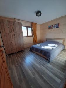 a bedroom with a bed and a wooden floor at Casute la munte in Râşnov