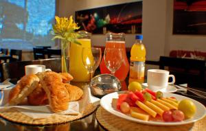 una mesa cubierta con un plato de comida y fruta en Hotel Castell, en Guayaquil