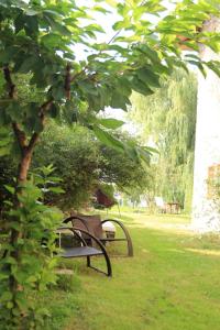 La CavadaにあるLa Ventanita Del Campoの木の下の芝生に座る公園のベンチ2つ