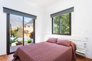 a bedroom with a bed and a large window at Apartamentos Los Mirlos in Valle Gran Rey