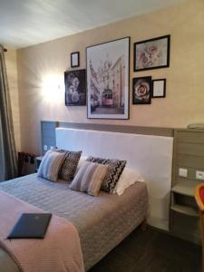 ein Schlafzimmer mit einem Bett und einem Laptop darauf in der Unterkunft Hôtel de la Plage in Saint-Palais-sur-Mer