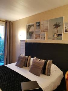 ein Hotelzimmer mit einem Bett mit Kissen in der Unterkunft Hôtel de la Plage in Saint-Palais-sur-Mer