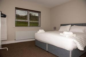 una camera da letto con un letto con due asciugamani sopra di Hillside House- Wild Atlantic Way a Burnfoot
