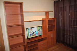 a living room with a tv in a wooden entertainment center at Apartamento PLAYA ARBEYAL in Gijón