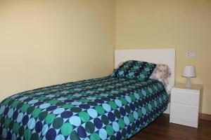 a bedroom with a bed and a night stand with a lamp at Apartamento PLAYA ARBEYAL in Gijón