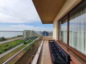 balcón con sofá y vistas al agua en Summerland Paradise, en Mamaia