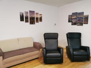 ein Wohnzimmer mit einem Sofa und 2 Stühlen in der Unterkunft Vila Valéria in Tatranská Lomnica