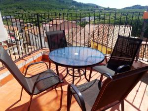 a patio with a glass table and chairs on a balcony at Casa Alba in Xert