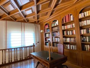 une chambre avec une table et des étagères avec des livres dans l'établissement VILLA BLANCA, à Olías del Rey