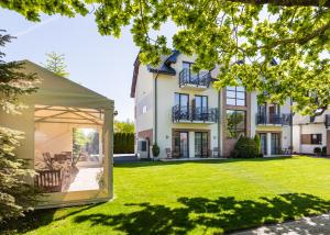 a house with a garden with a tent in the yard at Pokoje Palicki in Dźwirzyno