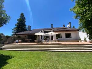 a white house with steps leading to a yard at Villa Blanca con piscina a 15 minutos de Toledo in Olías del Rey