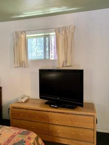 a flat screen tv on a wooden dresser in a bedroom at Stevenson’s Inn in Kings Beach +26 photos
