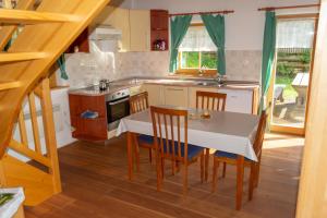 a kitchen with a table and chairs and a sink at house on the top of the hill in Mozirje